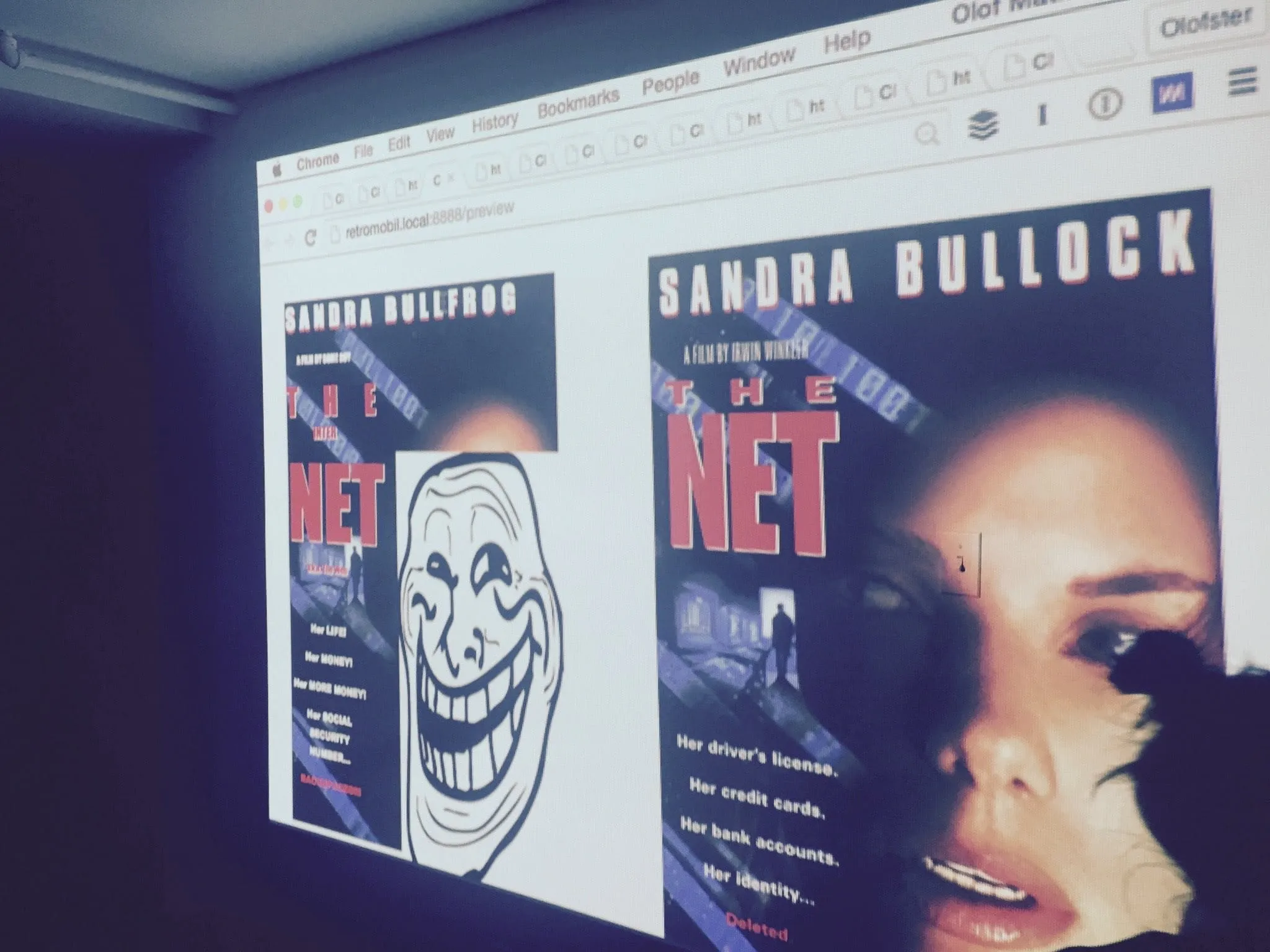 A projected side-by-side of the original poster for The Net and a contestant's parody retitled Sandra Bullfrog, complete with a troll face